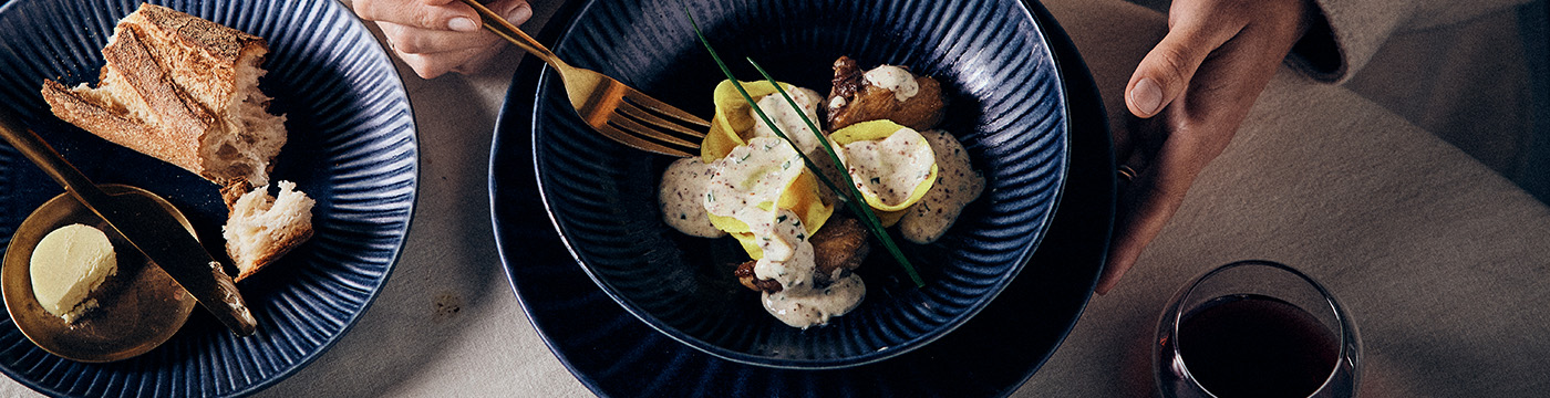 Tortellini with mustard cream sauce & duck leg confit served in a bowl