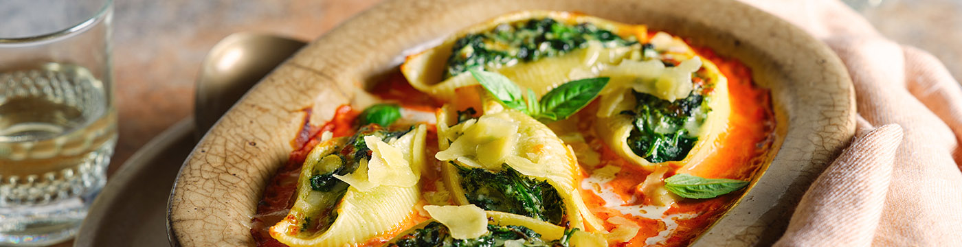 Cheese & tomato baked conchiglioni pasta served in a baking dish 